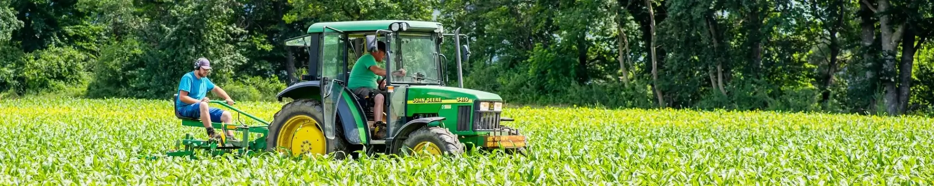 Header Home Man on tractor in a green field