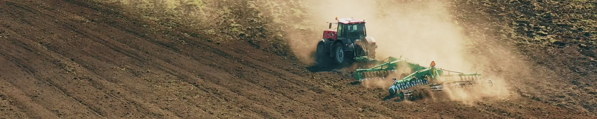 Traktor im Einsatz auf dem Feld – Förderung umweltbewusster Landwirtschaft mit World Climate Farm Tool für Klimabilanzen